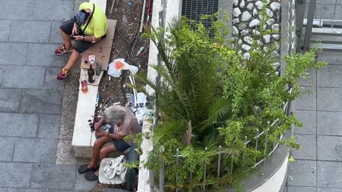 Two homeless men drinking on street, high angle pov 動画素材 280736445