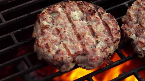Two homemade burger cutlets made of meat and onions are roasting on the grill Stock Footage 148873337