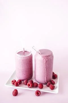 Two Homemade Raspberry Smoothies on Light Pink Background  Fresh and Health.. Foto stock