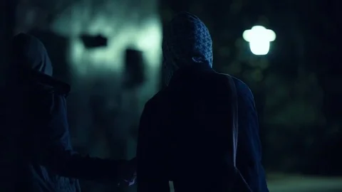 Two hooded men doing transaction at night,suspicious activity Stock Footage 73888502