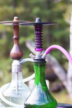 Two hookahs ready to use are on the table Stock Photos