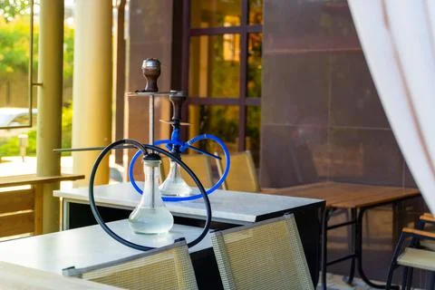 Two hookahs stand on the table in the restaurant ready for use Stock Photos