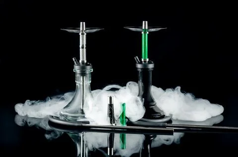 Two hookahs with white puffs of smoke on a black mirror background. Artistic  Stock Photos