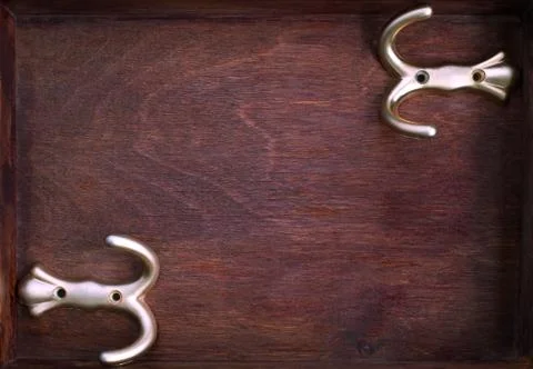 Two horizontal gold hooks into old dark box Stock Photos