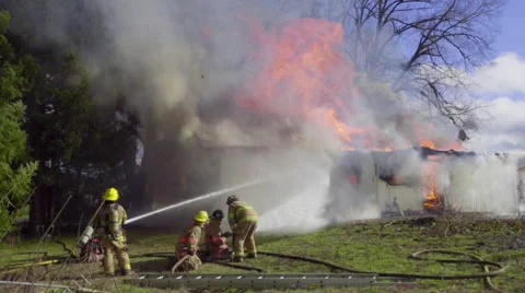 Two hoses spray burning house Stock Footage 60985644