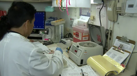 Two hospital lab techs labeling blood samples Stock Footage 37911998