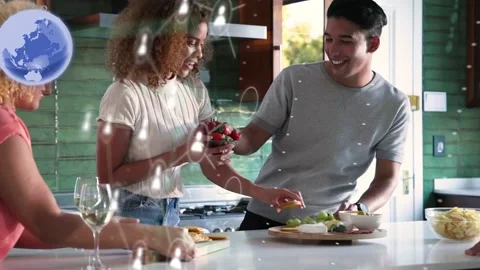 Two hosts standing at island, hands reaching, passing berries, preparing snacks, Stock Footage 333949786