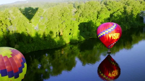 Two hot air balloons float about the water Stock Footage 56604165