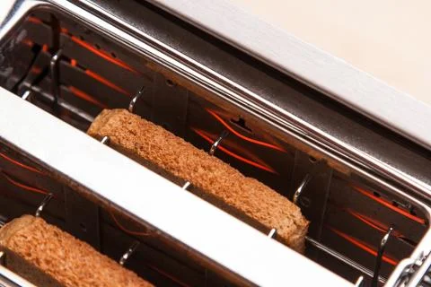Two hot bread toast in toaster Stock Photos