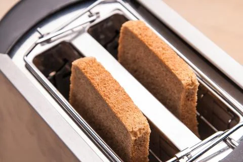 Two hot bread toast in toaster Stock Photos