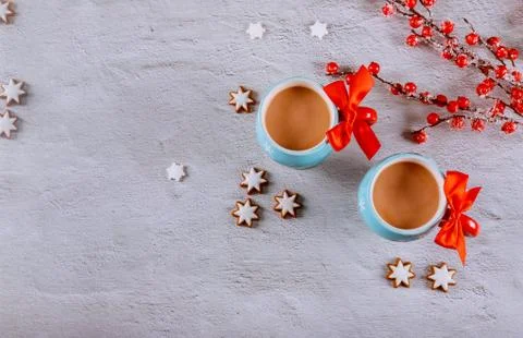 Two hot cacao in cups with red bowl, star shape cookie and red berry branch o Stock Photos
