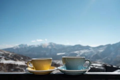 Two hot coffee or tea cup outdoor on nature background, winter mountains and sky Stock Photos