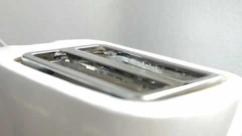 Two hot slices of toasted bread popping out of a white kitchen toaster, a Stock Footage 329757825