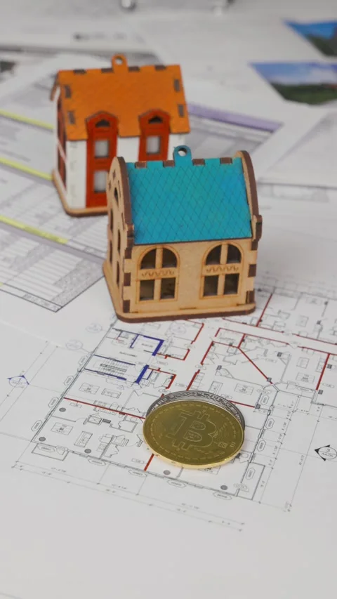 Two house models are on the blueprints, and a hand places bitcoin coins Stock-Footage 305638532