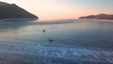 Two hovercraft ride on the ice of Lake Baikal at dawn Stock Footage 116561844
