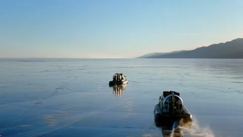 Two Hovercrafts move over thin ice on frozen Baikal lake. Winter water transport Stockbeeldmateriaal 344804444