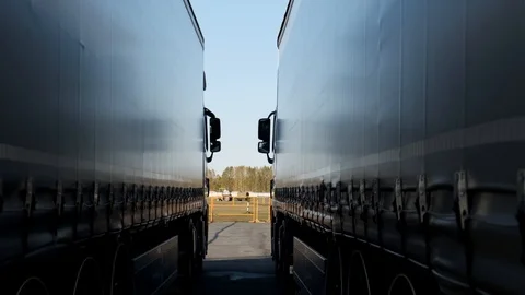 Two huge trucks are standing next to each other in hub, loaded with products Stock Footage 119049692
