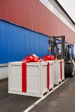 Two huge white boxes with a gift and a huge red bow on a skid steer Stock Photos