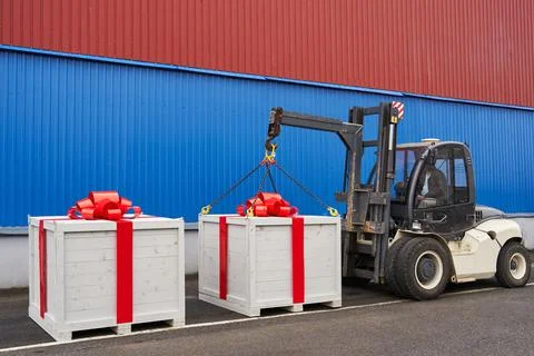 Two huge white boxes with a gift and a huge red bow on a skid steer Stock Photos