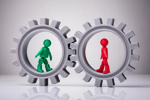 Two Human Figures Walking In Interlocked Gears Stock Photos