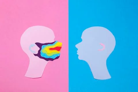 Two human profiles cut out of paper and profile on the left is in a rainbow mask Stock Photos