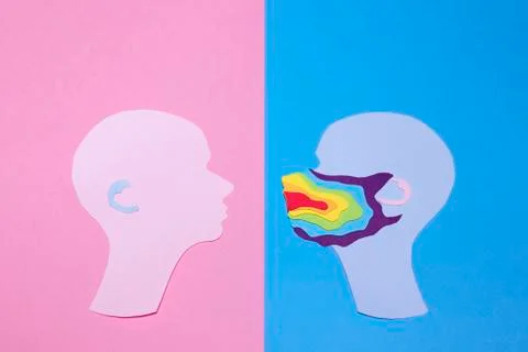 Two human profiles cut out of paper and profile on the right is in rainbow mask Stock Photos
