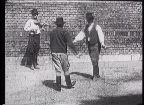 Two hungarian men dancing while third one is playing violin Stock Footage 159725000