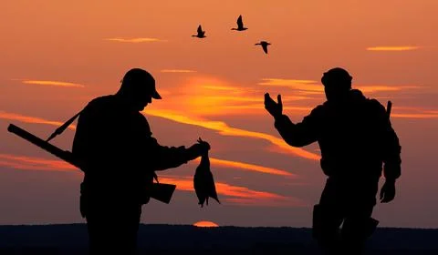 Two hunters at sunset Stock Photos