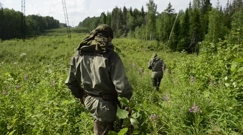 Two hunters walk down the hill Stock Footage 43342467