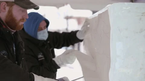 Two Ice carvers making ice sculpture at winter festival in Carmel Indiana Stock Footage 151101379