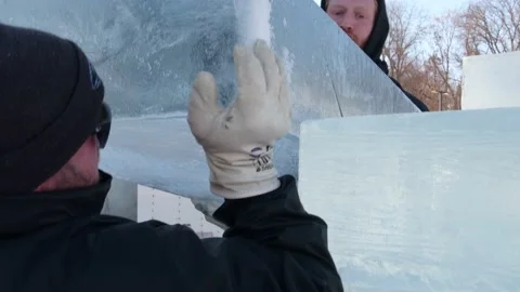 Two ice carvers moving ice block together for ice sculpting competition Stock Footage 146916870