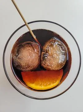 Two ice cubes and an orange slice in a drink symbolizing a smiling face Stock Photos