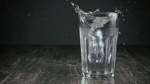 Two ice cubes fall into a glass of water Video stock 94669945