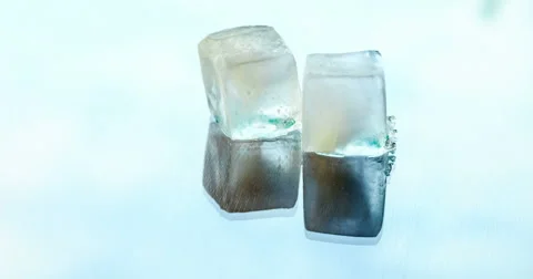 Two ice cubes melting on the glass surface on a background of running clouds 库存影片 66882014