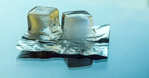 Two ice cubes melting on the glass surface on a background of running clouds 库存影片 66890104