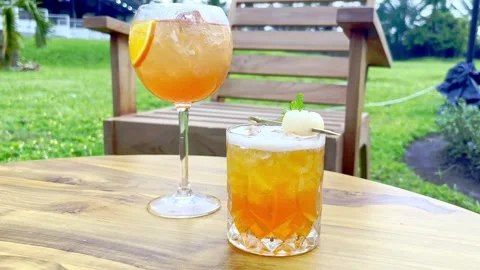 Two iced cafe drinks on garden table Stock Footage 335430511