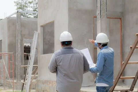 Two Indian engineering people talking with mobile phone to customer in fron.. Stock Photos