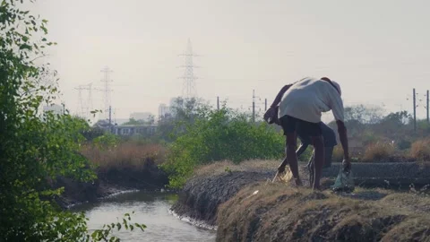 Two Indian fishermen by the lake pulling the fishing net out of the water Vídeo Stock 337092806