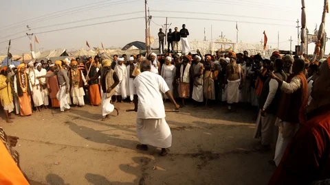 Two indian men show martial art on long sticks among crowd of people hindu festi Stock Footage 106834996