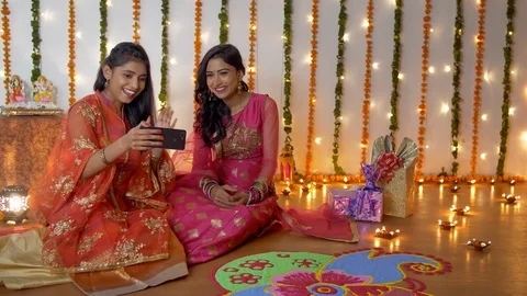 Two Indian sisters happily doing video call with a smartphone on Diwali festival Stock Footage 117487630