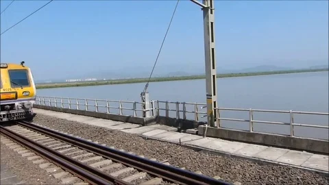 Two Indian trains meet &amp; cross each other on sea railway bridge, Mumbai India Stock Footage 98917209