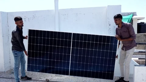 Two indian workers holding solar panel read to instal at roof of house. Stock Footage 270754616
