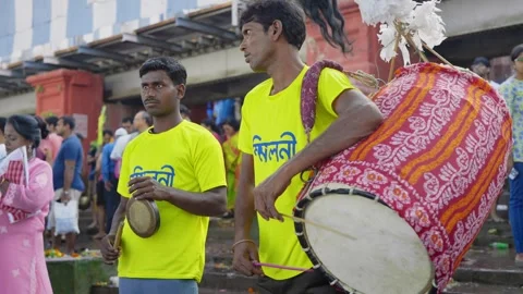 Two indian young men playing dholak and brass bell during dussehra durga puja. Stock Footage 268438672