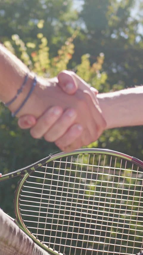 Two Individuals Shaking Hands over Tennis Racket Vidéo 317959594