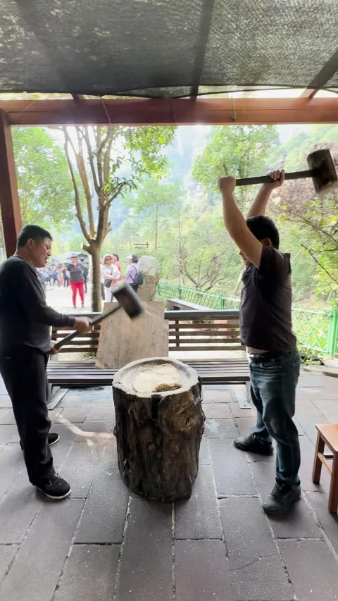 Two individuals using large wooden mallets to pound Stock Footage 313283963