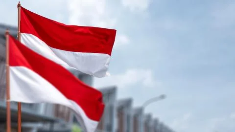 Two Indonesian flags flutter outdoors against a blue sky, celebrating natio.. 写真素材