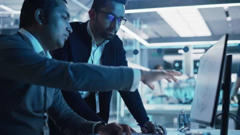 Two Industrial Developers Working on Computer Video stock 229842320