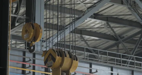 Two Industrial Yellow Hooks That Slowly Swing (4K) Stock Footage 60767888
