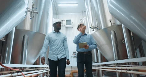 Two Industry Engineers Walk in Factory, Use Tablet and Discuss Work Stock Footage 164537828
