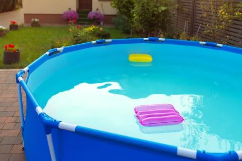 Two inflatable pillows lie on the surface of the water in the pool Stock Photos